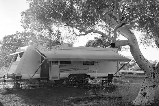 Caravan parked at the side of a lake on the grass