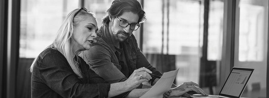 a female and male colleague looking at a document