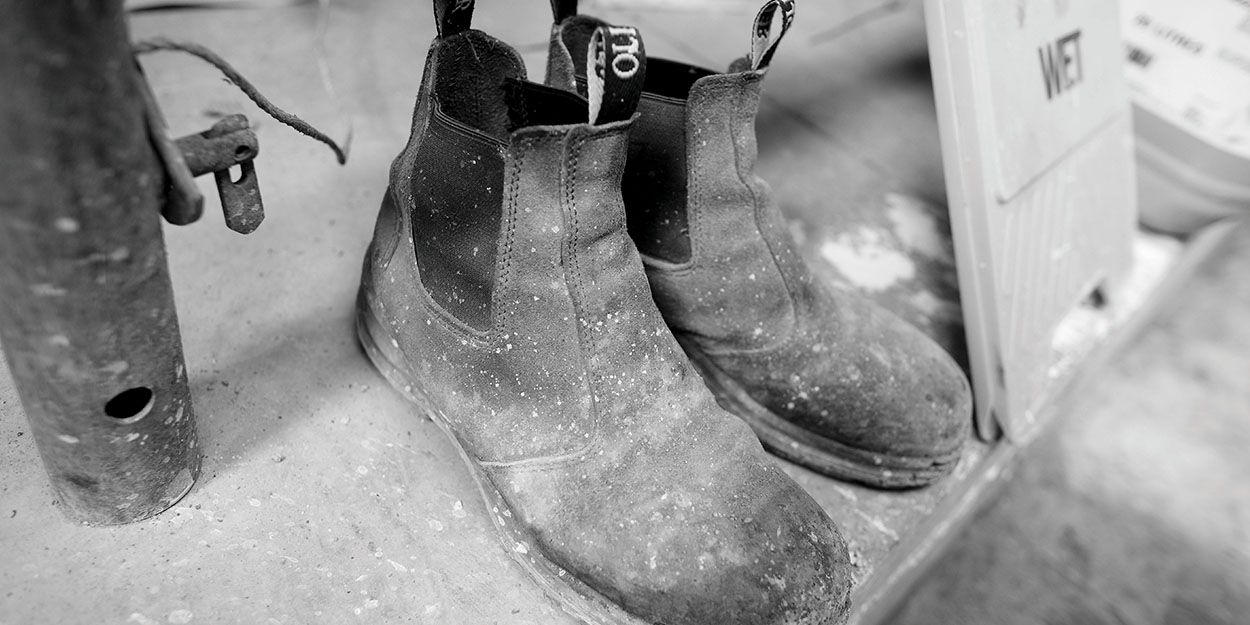 a pair of construction boots with paint on them