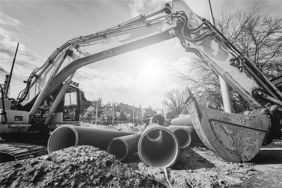 excavator on a construction site with piping