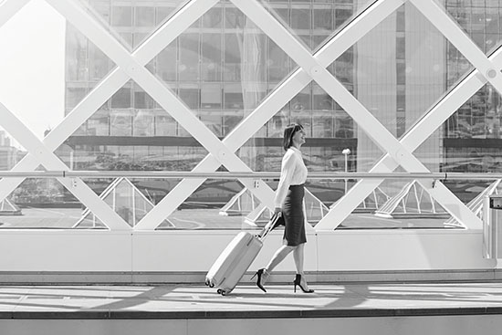 Business woman walking through the airport with luggage
