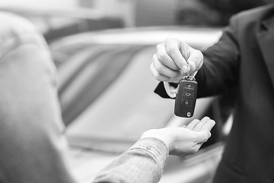 hands showing a car salesman handing over the keys to a customer