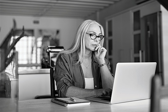 a small business owner working on a laptop in her home
