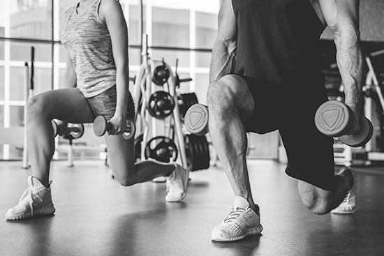 two male athletes training at the gym with weights