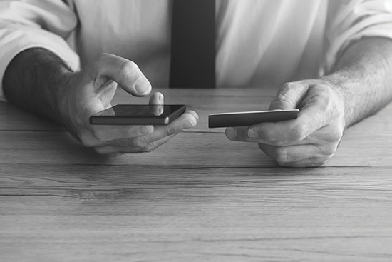 male hands looking at credit card and phone